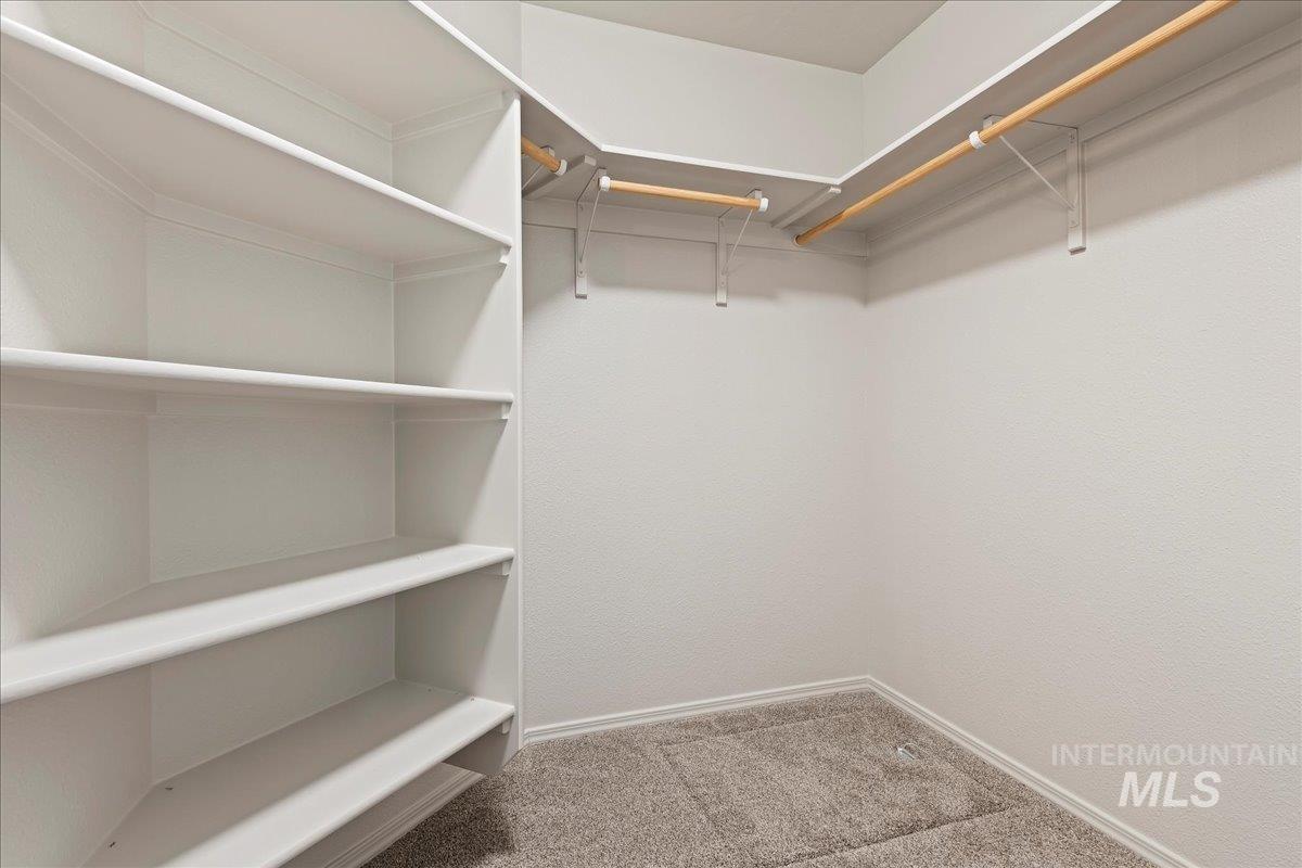 Spacious closet with light colored carpet