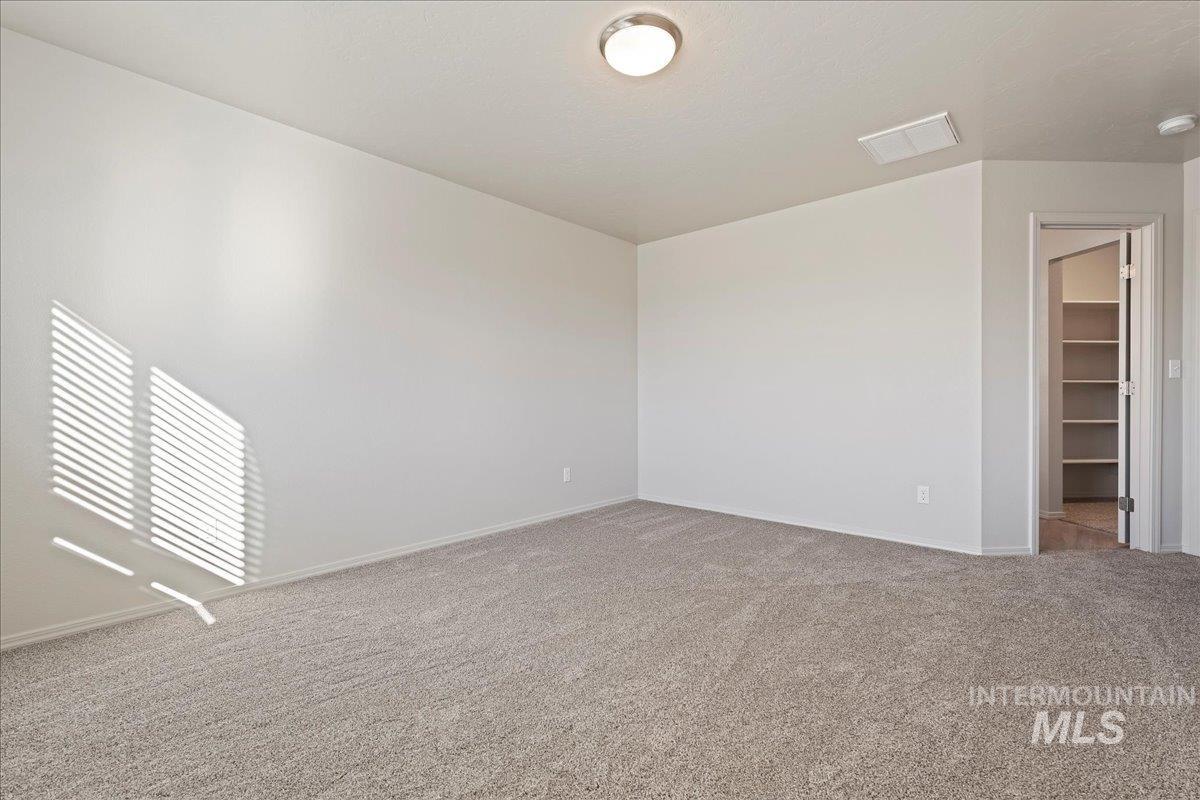 Empty room featuring carpet flooring and baseboards
