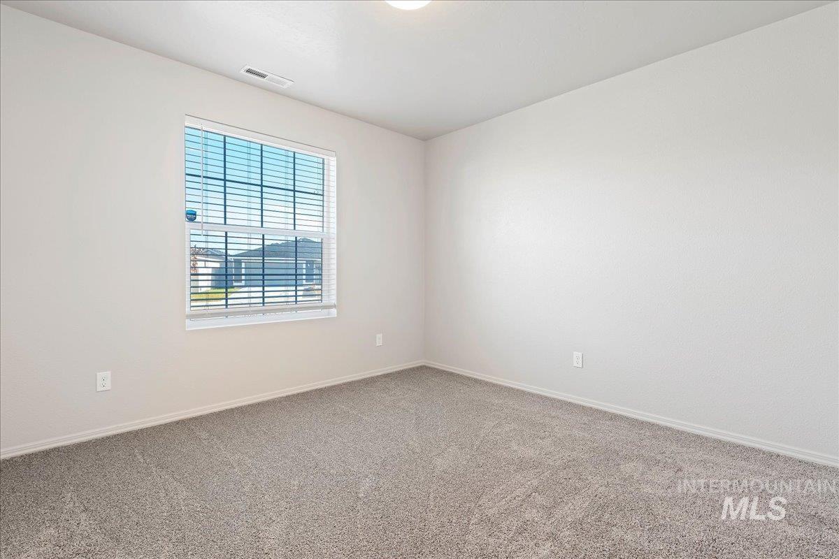 Carpeted empty room featuring baseboards