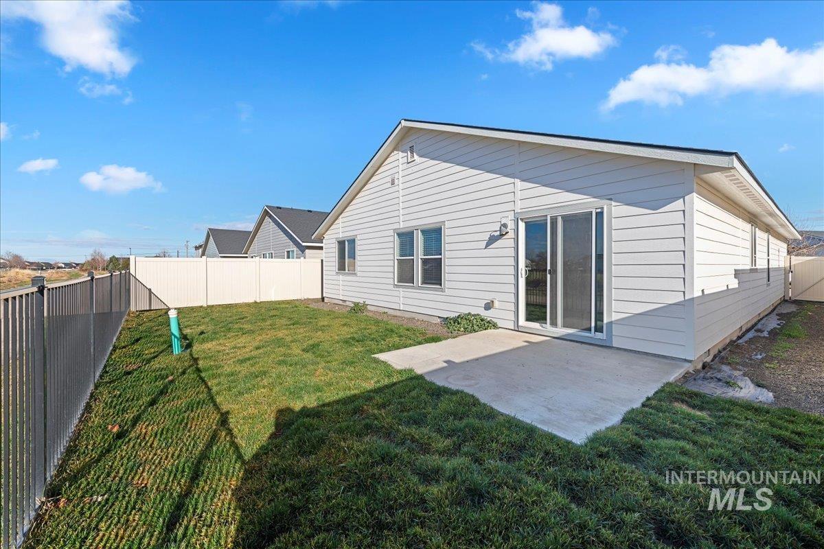 Rear view of property with a fenced backyard and a patio
