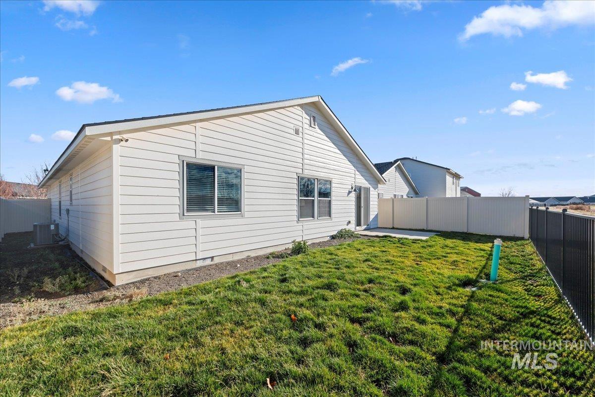 Back of house with a fenced backyard and a patio area