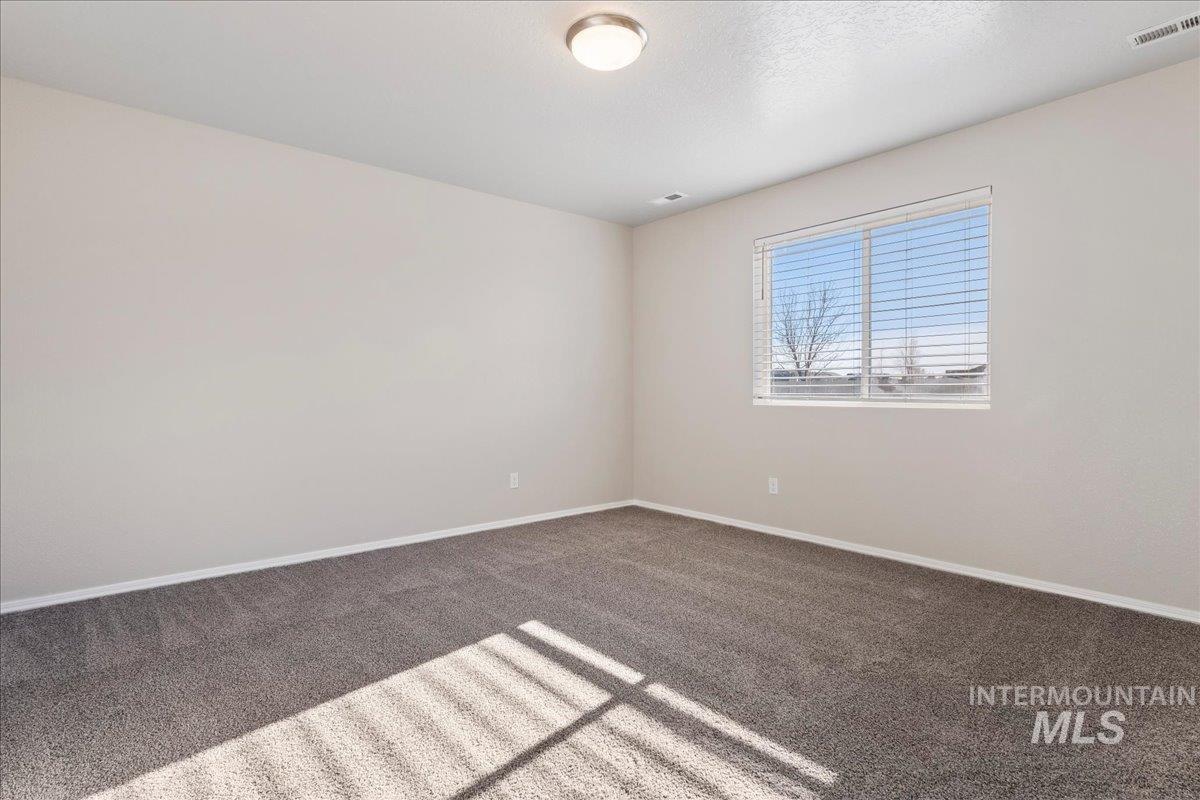 Unfurnished room featuring dark colored carpet