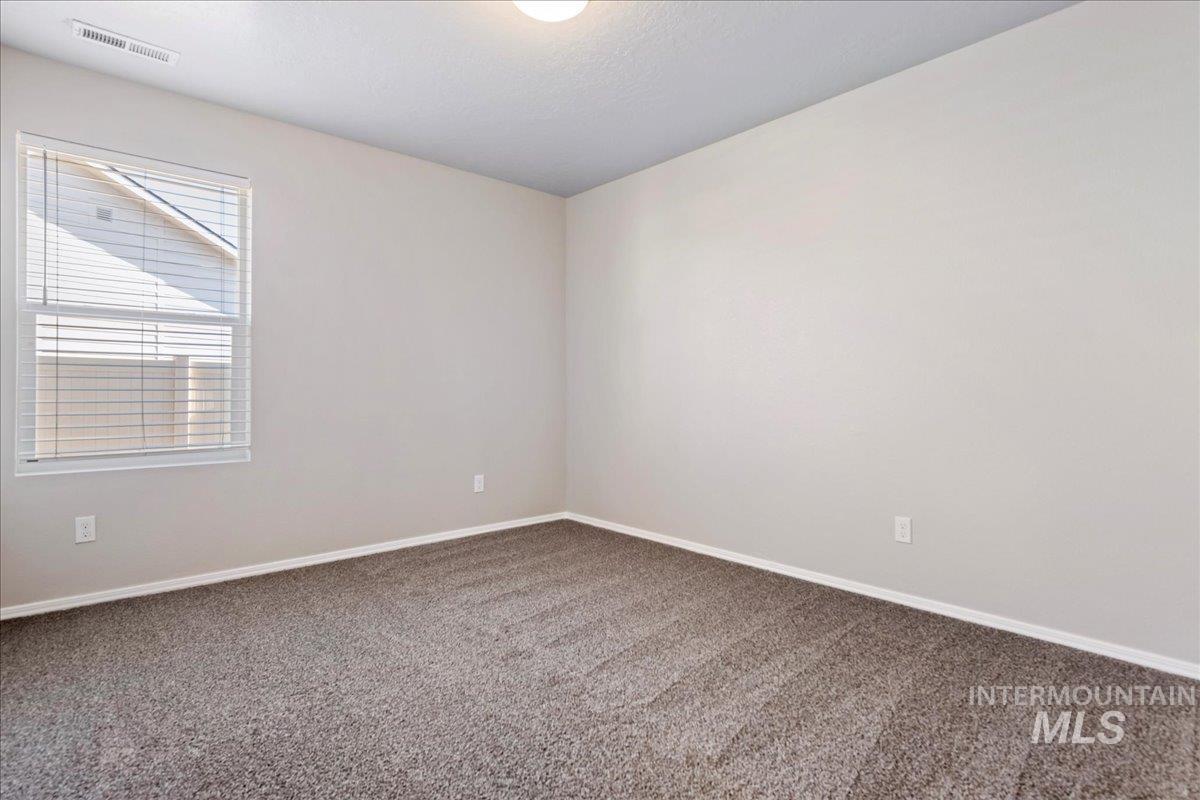 Carpeted spare room with baseboards