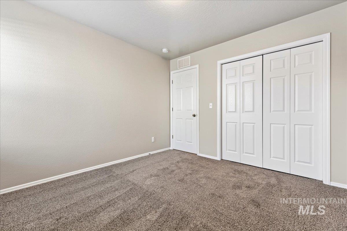 Unfurnished bedroom with dark colored carpet and a closet
