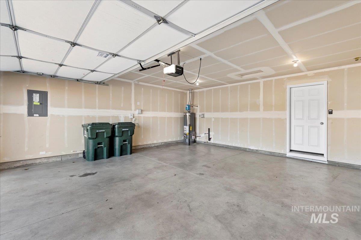 Garage featuring electric panel and gas water heater