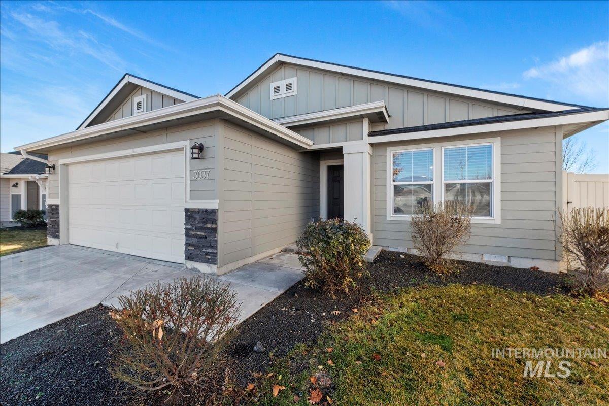 View of front of home with board and batten siding, driveway, and a garage