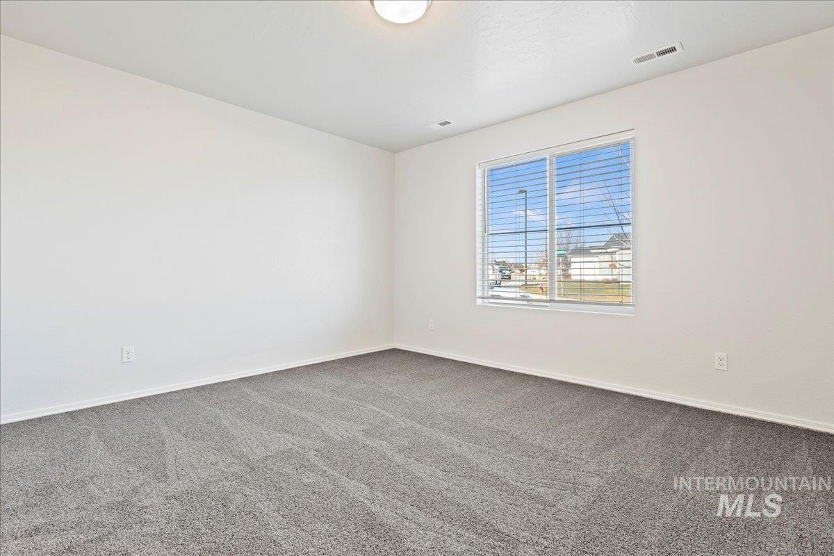 Carpeted empty room featuring baseboards