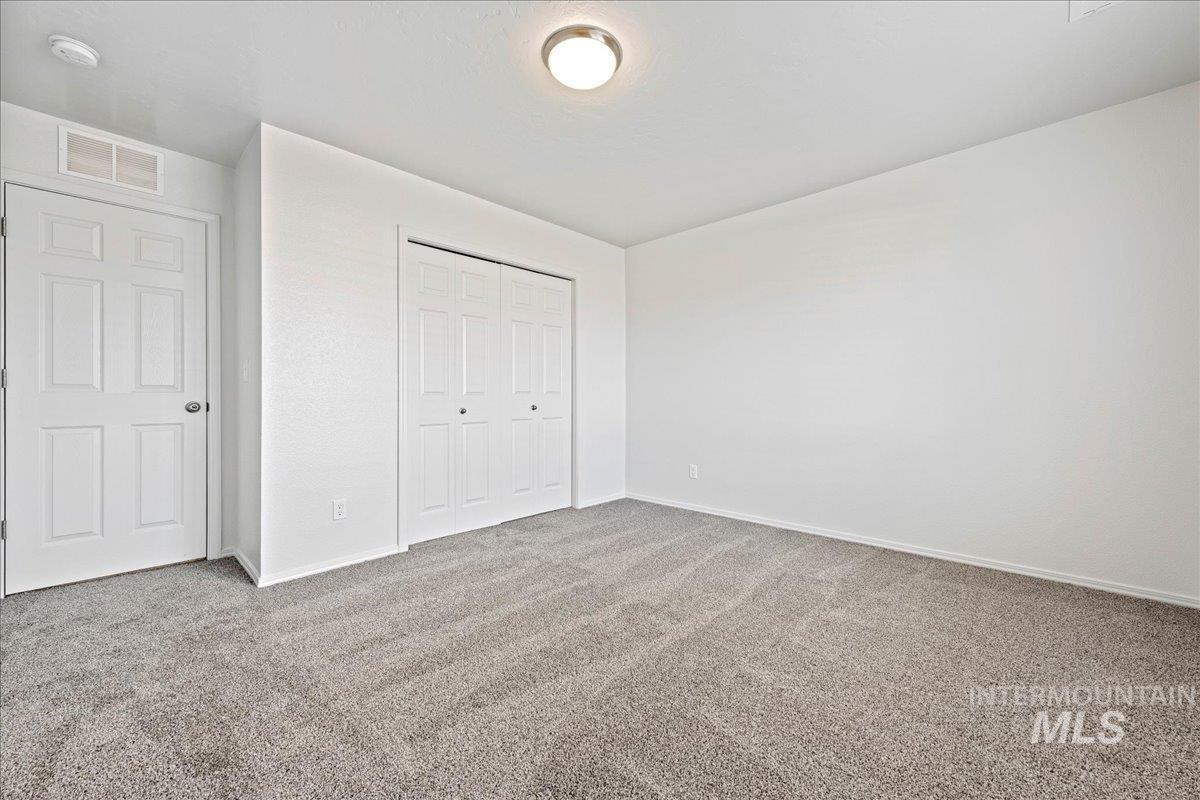 Unfurnished bedroom with light colored carpet and a closet
