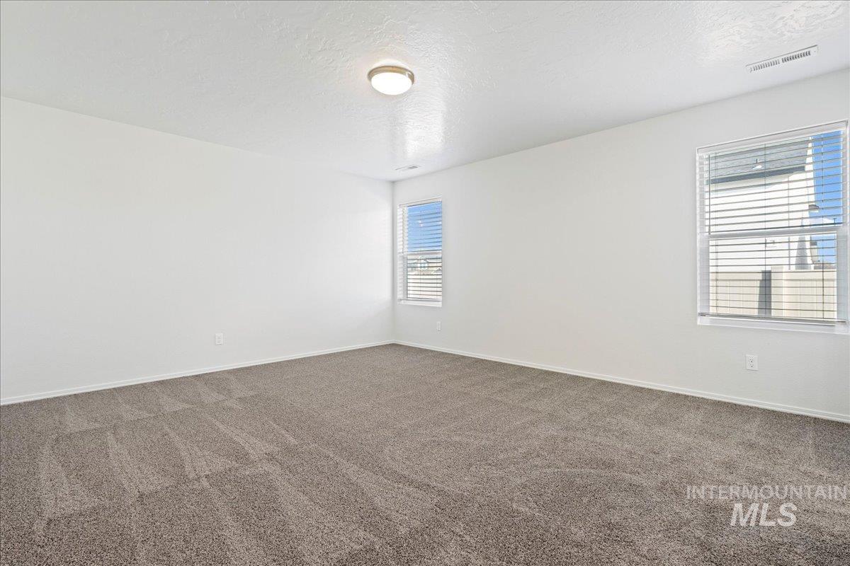 Unfurnished room with a textured ceiling and carpet floors