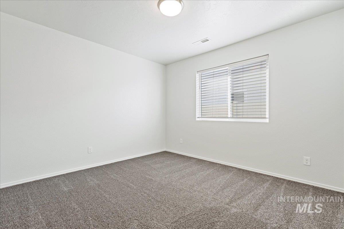 Spare room featuring carpet and baseboards
