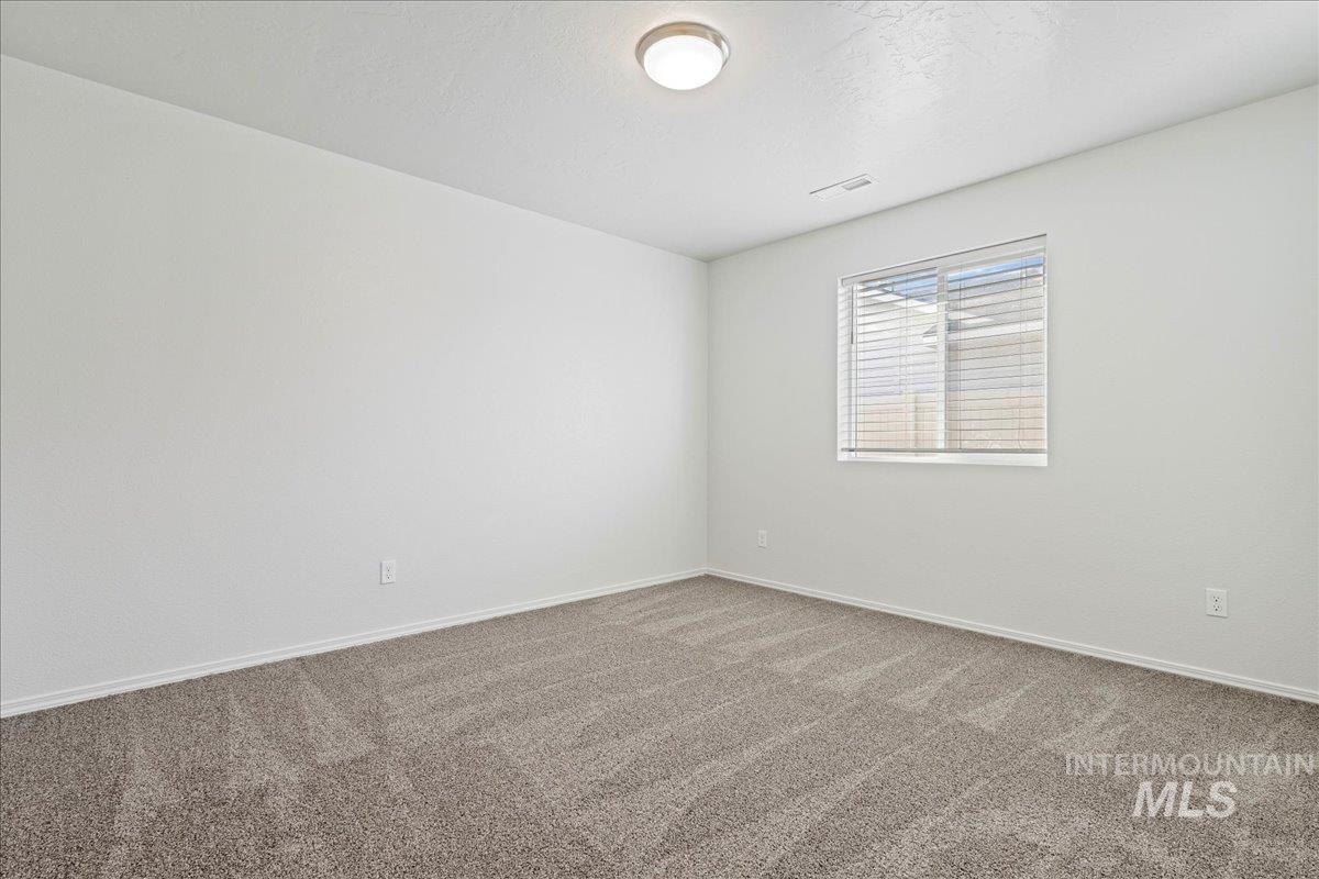 Spare room with carpet flooring and a textured ceiling