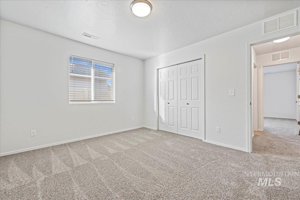 Unfurnished bedroom with carpet floors, a closet, and a textured ceiling