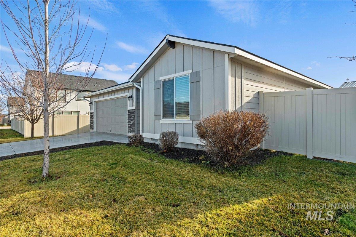 View of side of home with board and batten siding, driveway, and an attached garage