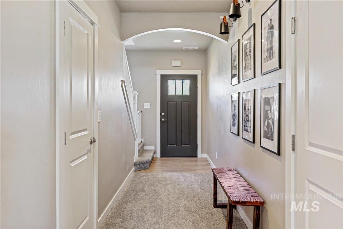 Entryway featuring arched walkways and carpet floors