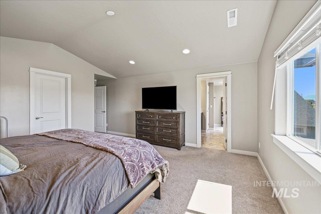 Carpeted bedroom featuring lofted ceiling and recessed lighting