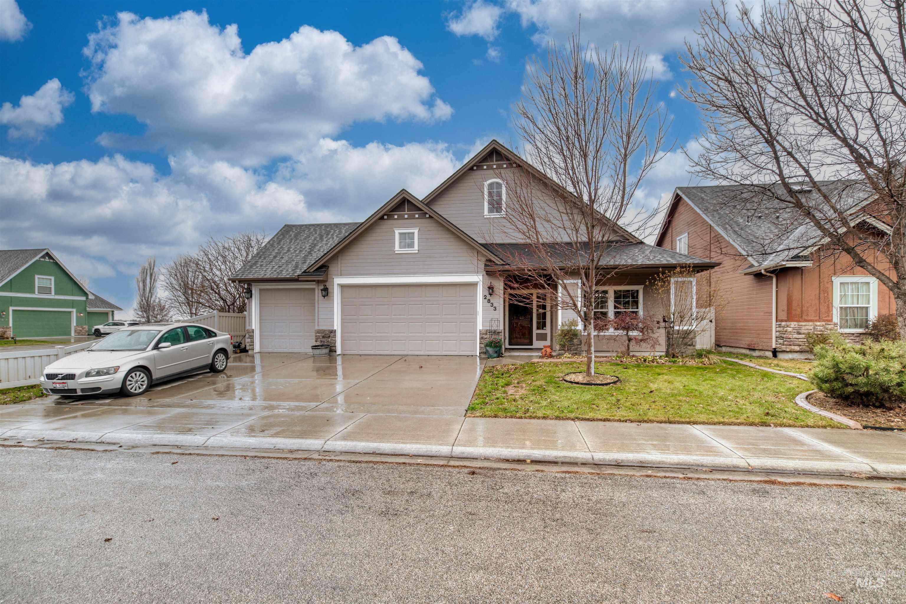 View of front of home with a front lawn, driveway, a garage, and covered porch