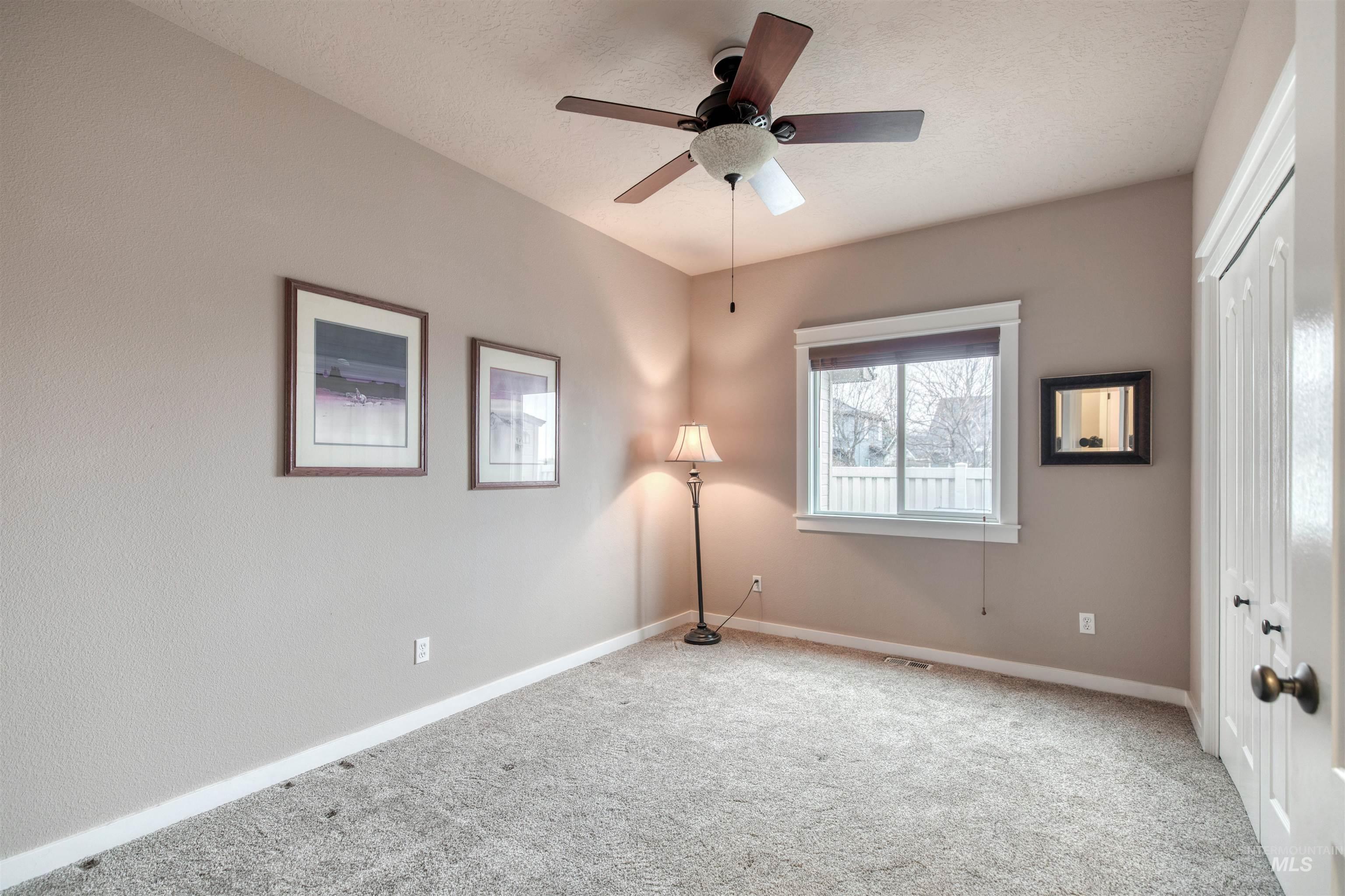 Unfurnished bedroom featuring a closet, carpet flooring, a ceiling fan, and a textured ceiling