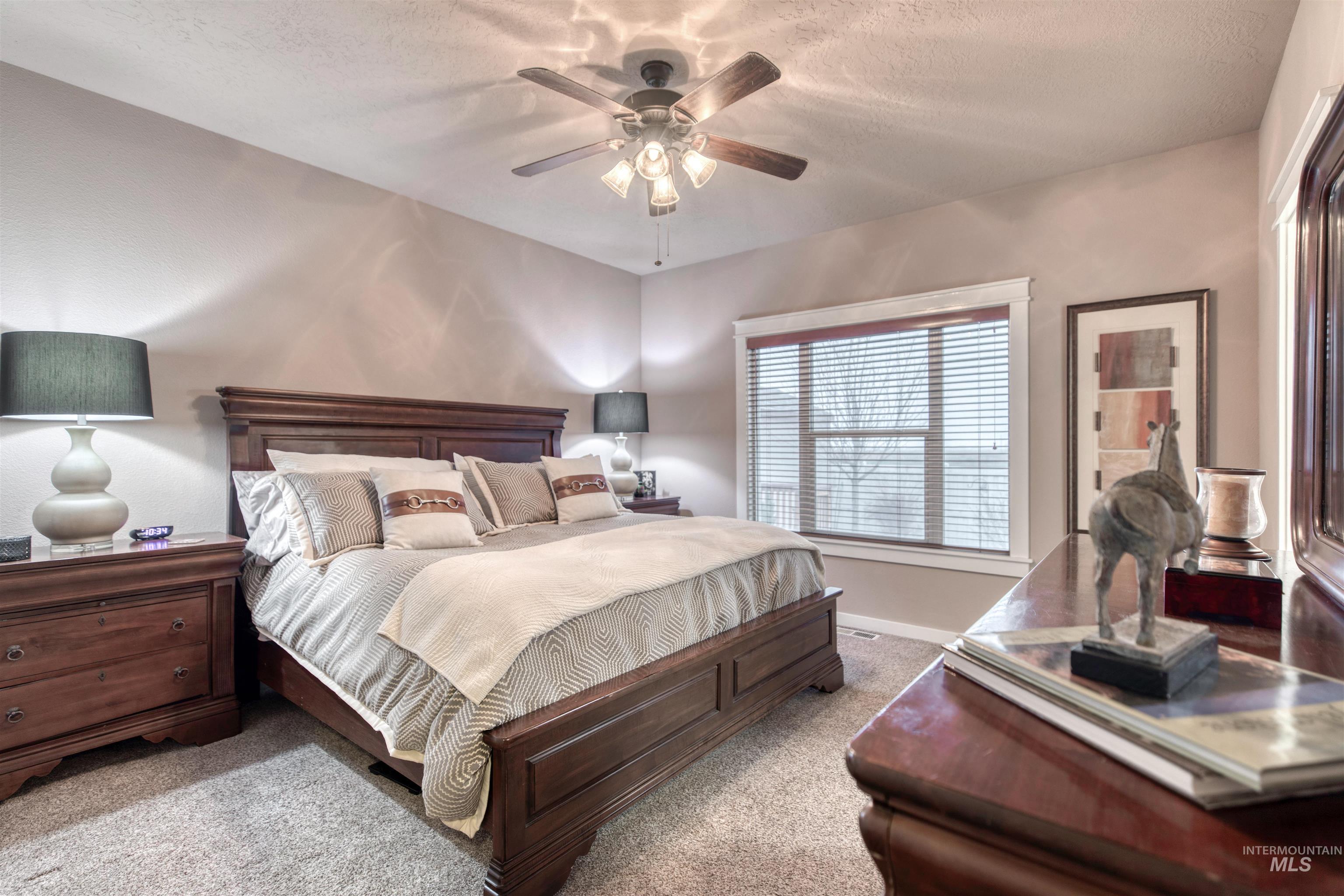 Bedroom featuring carpet flooring, ceiling fan, and a textured ceiling