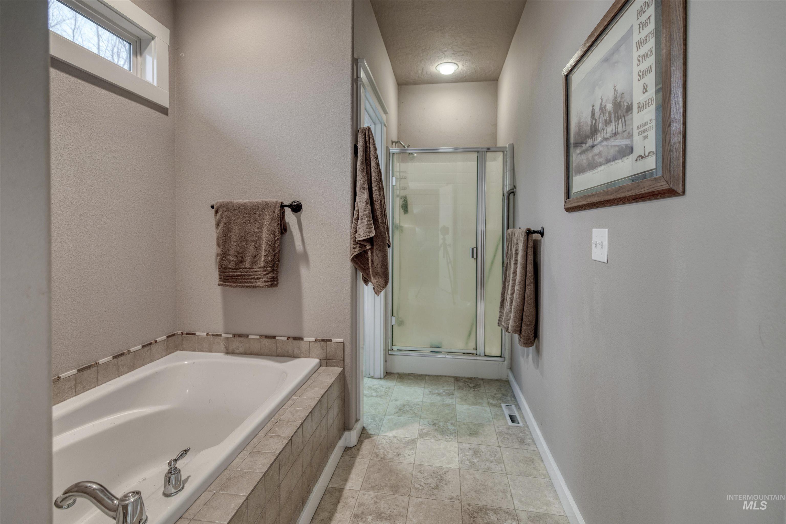 Bathroom featuring a stall shower and a garden tub