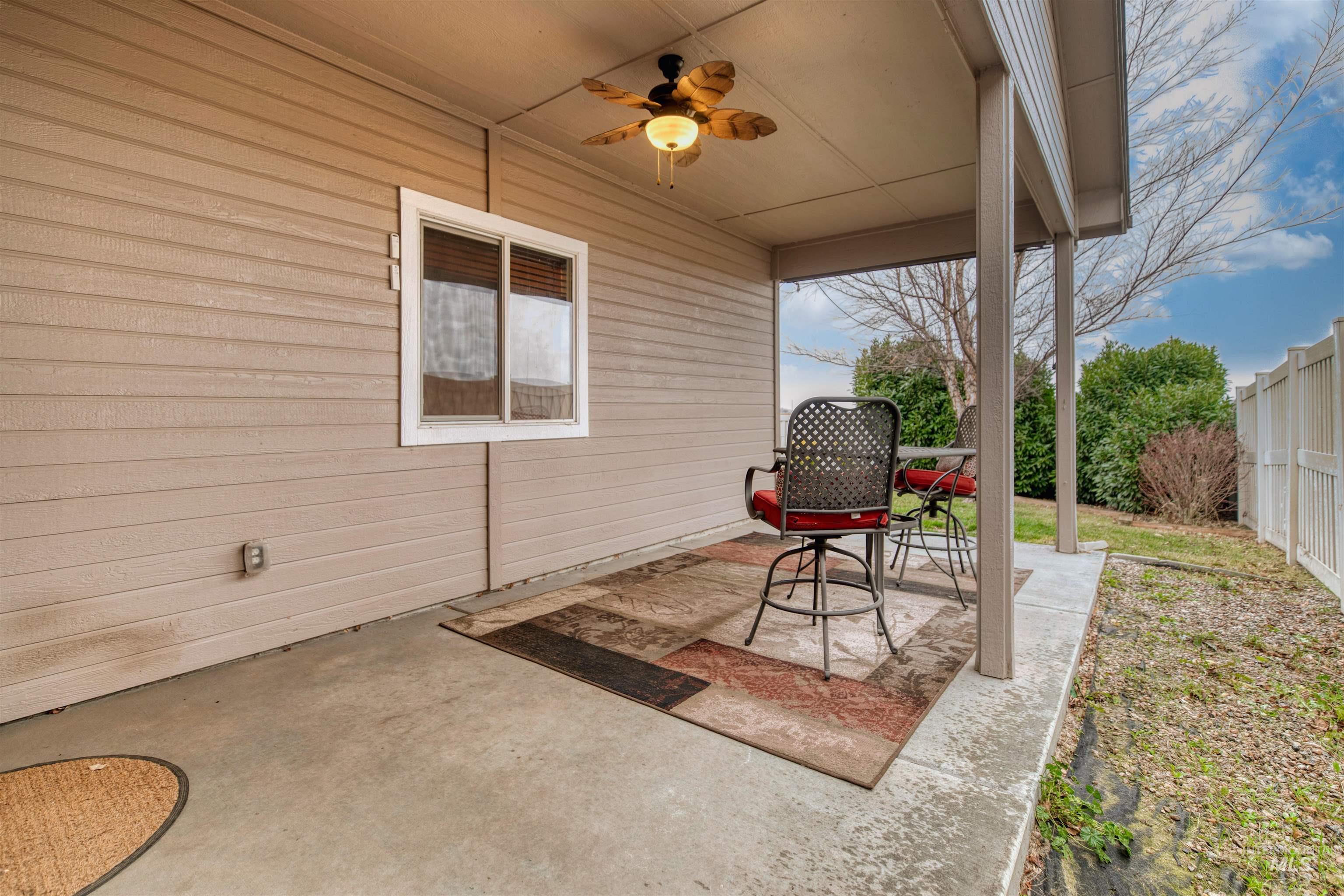 Fenced backyard with a patio and ceiling fan