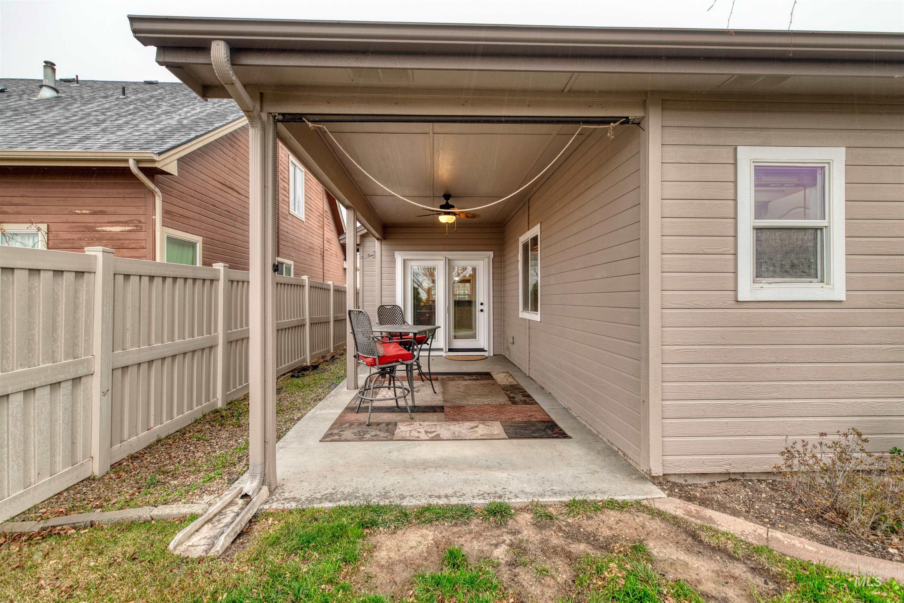 Entrance to property with a ceiling fan and a patio area