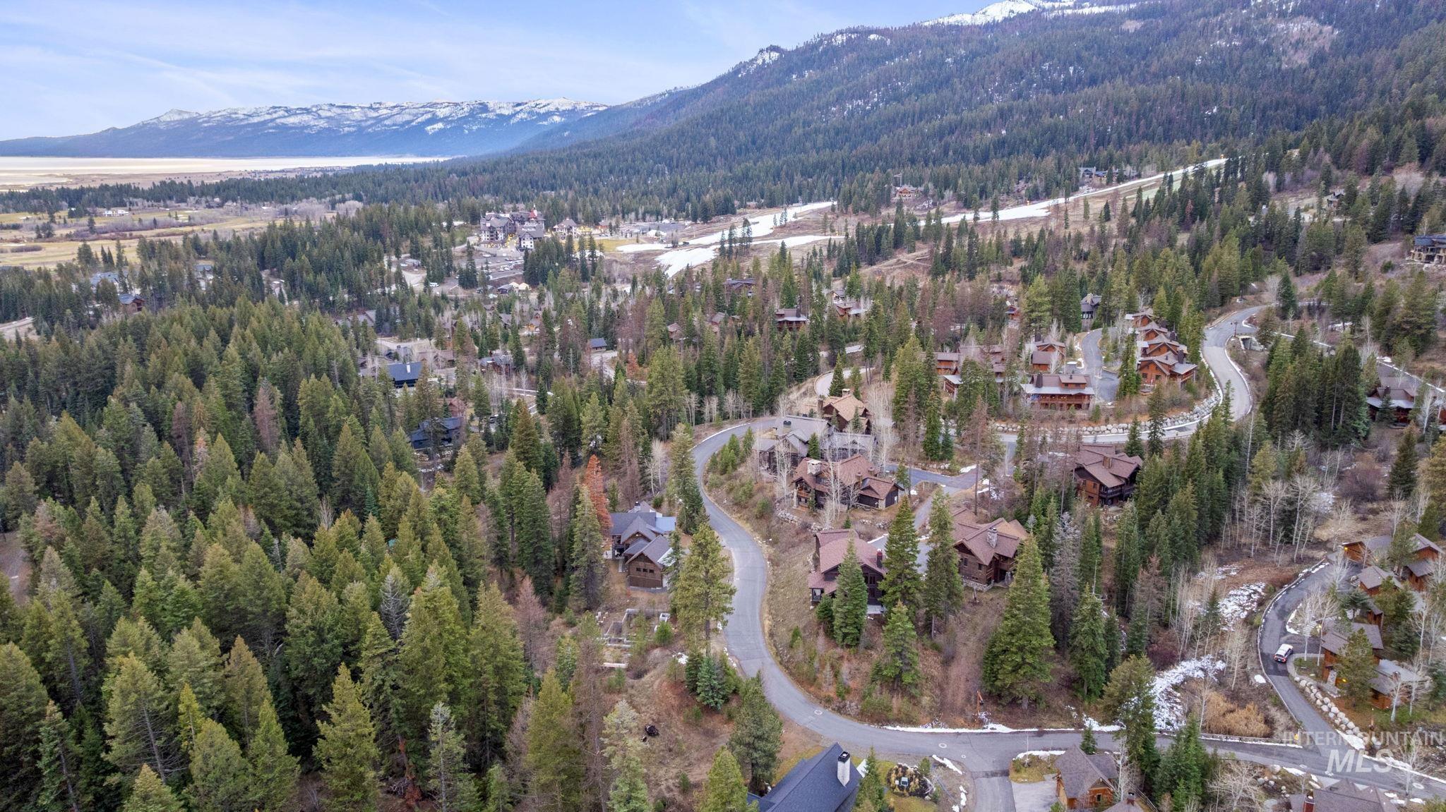 View of property location with a mountain backdrop and a heavily wooded area