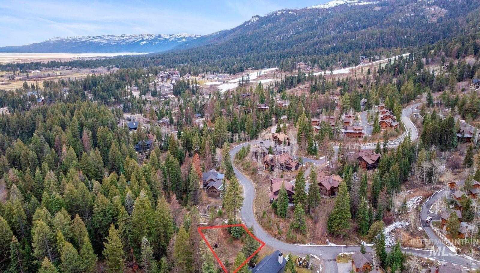 Aerial view of property and surrounding area with a mountain backdrop
