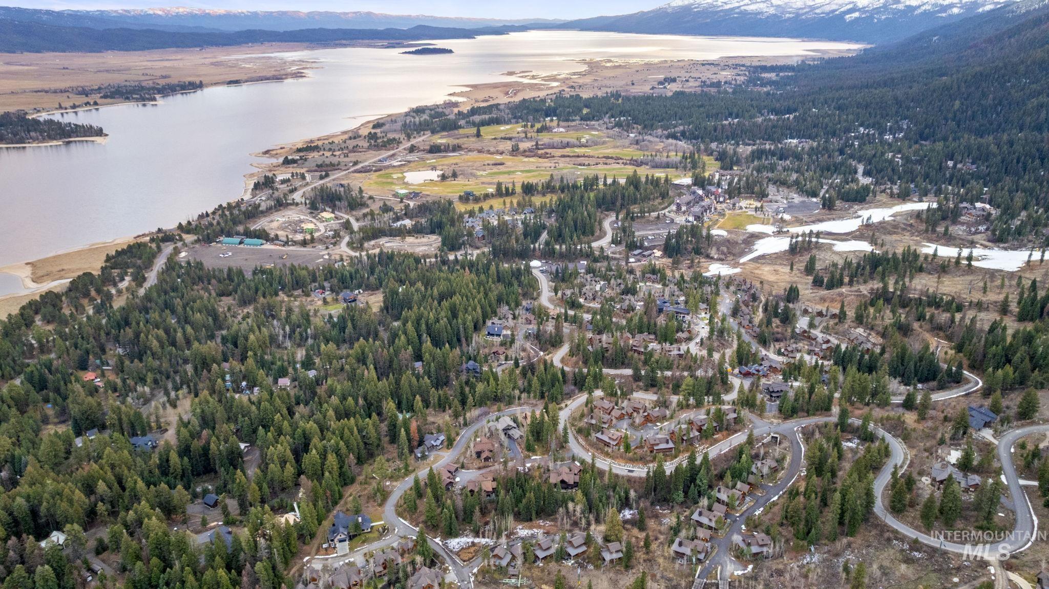 Aerial view of property and surrounding area with a water and mountain view and a heavily wooded area