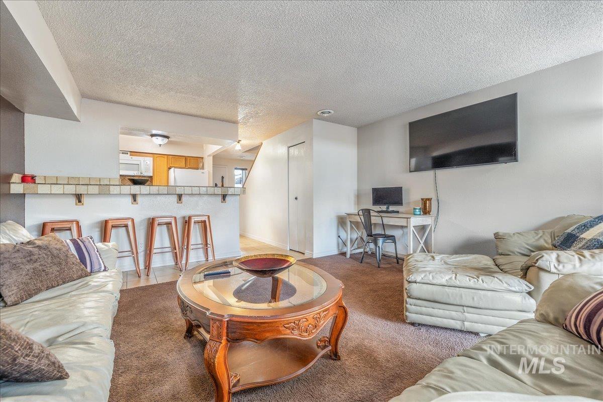 Living room with a textured ceiling and a desk