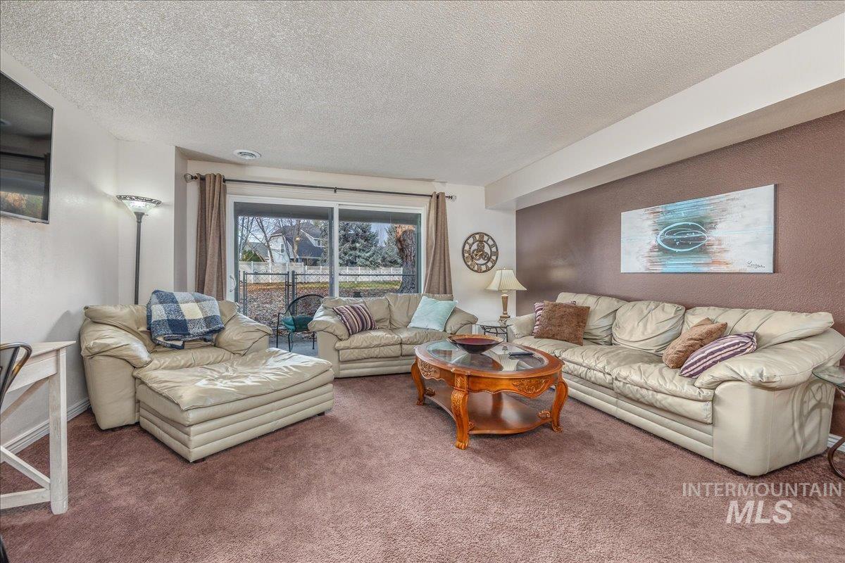Living area featuring carpet flooring and a textured ceiling
