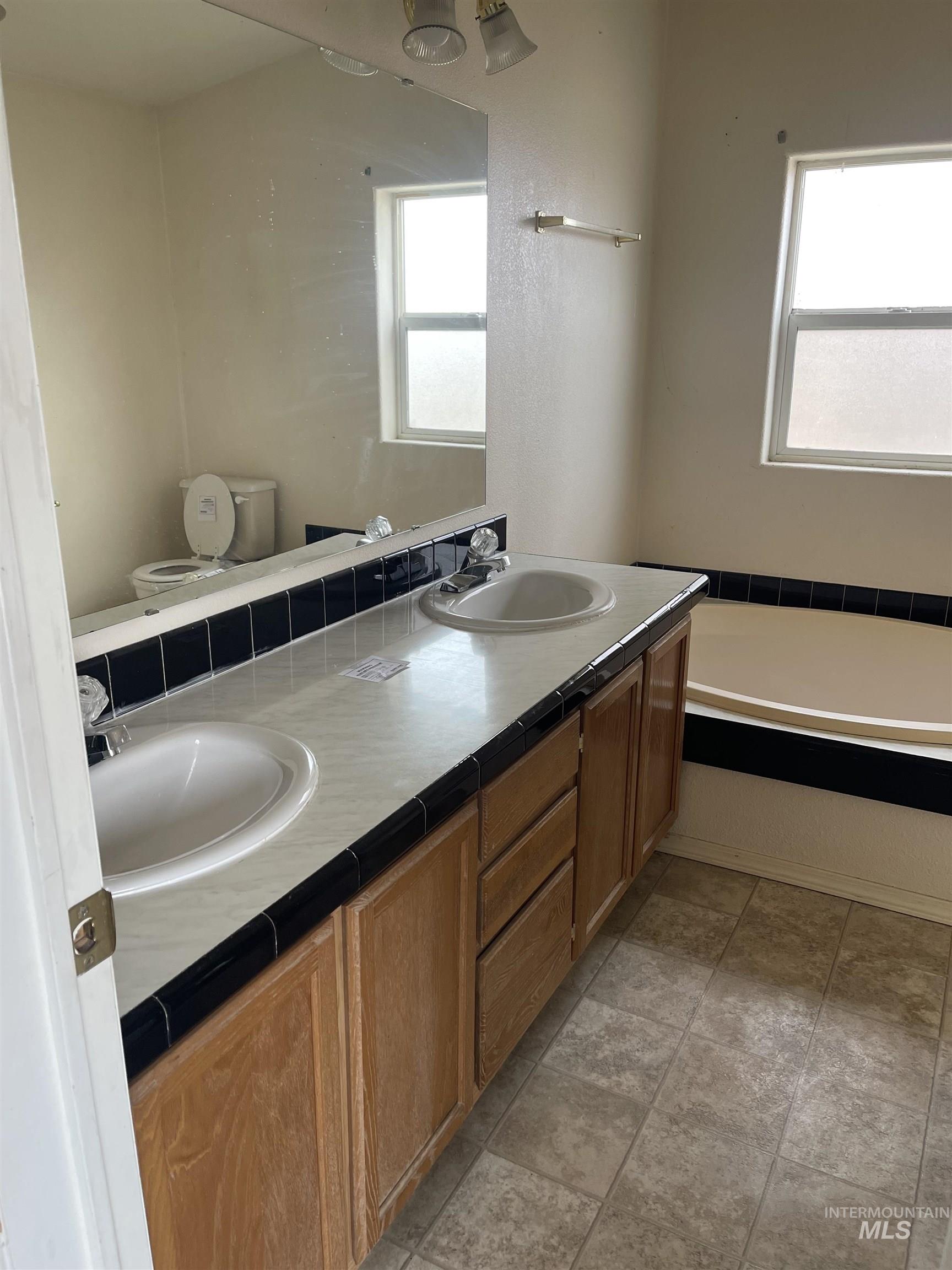 Bathroom featuring double vanity and a bath