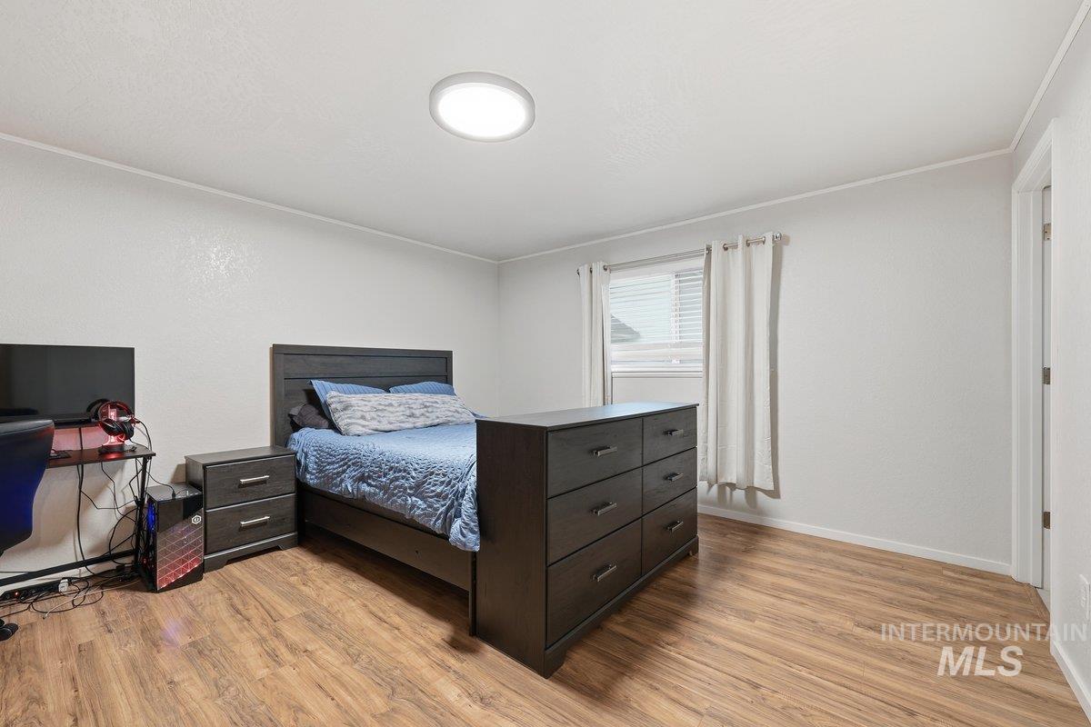 Bedroom with light wood finished floors and baseboards