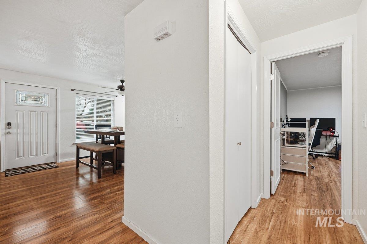 Hall featuring light wood-type flooring and a textured ceiling