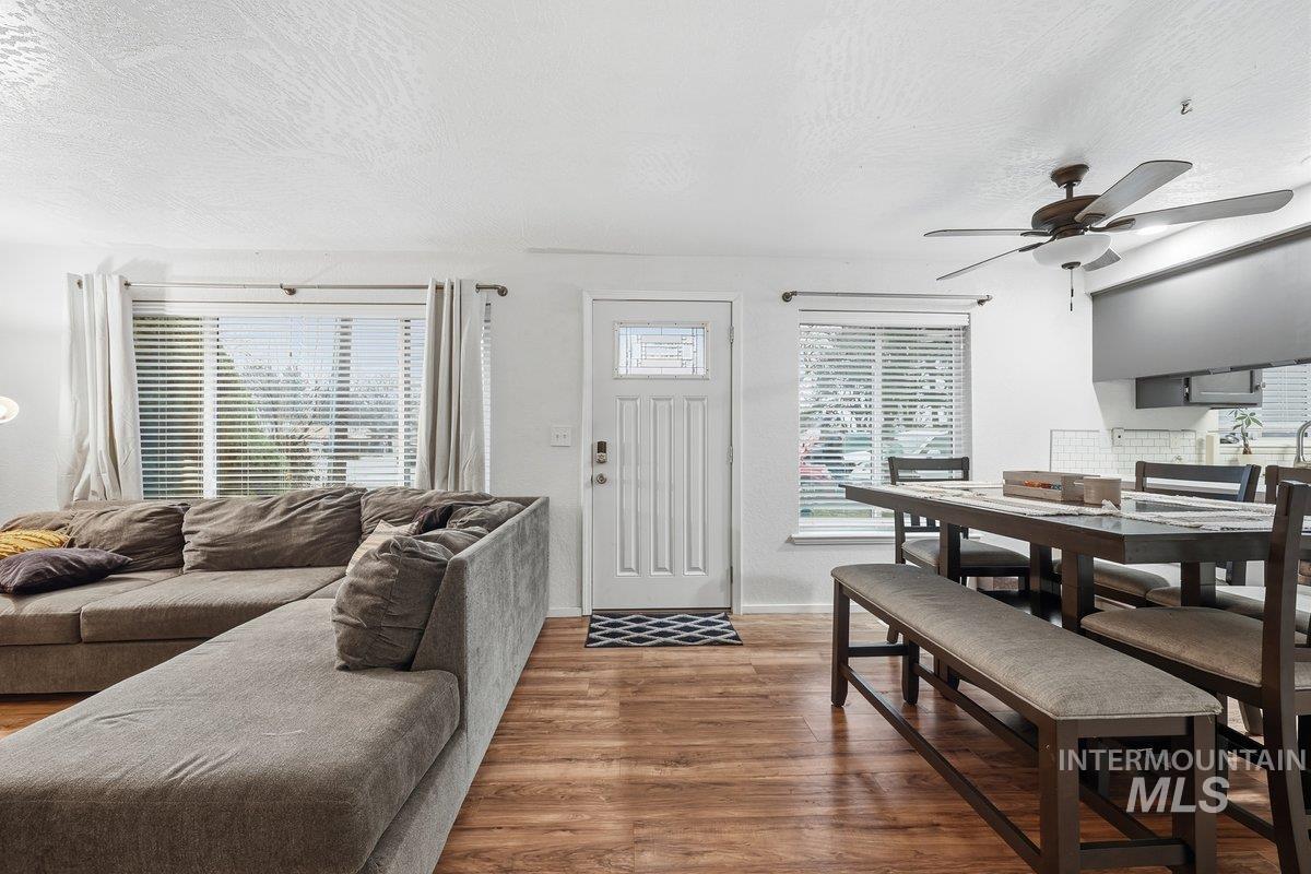 Living area with a textured ceiling, wood finished floors, plenty of natural light, and ceiling fan