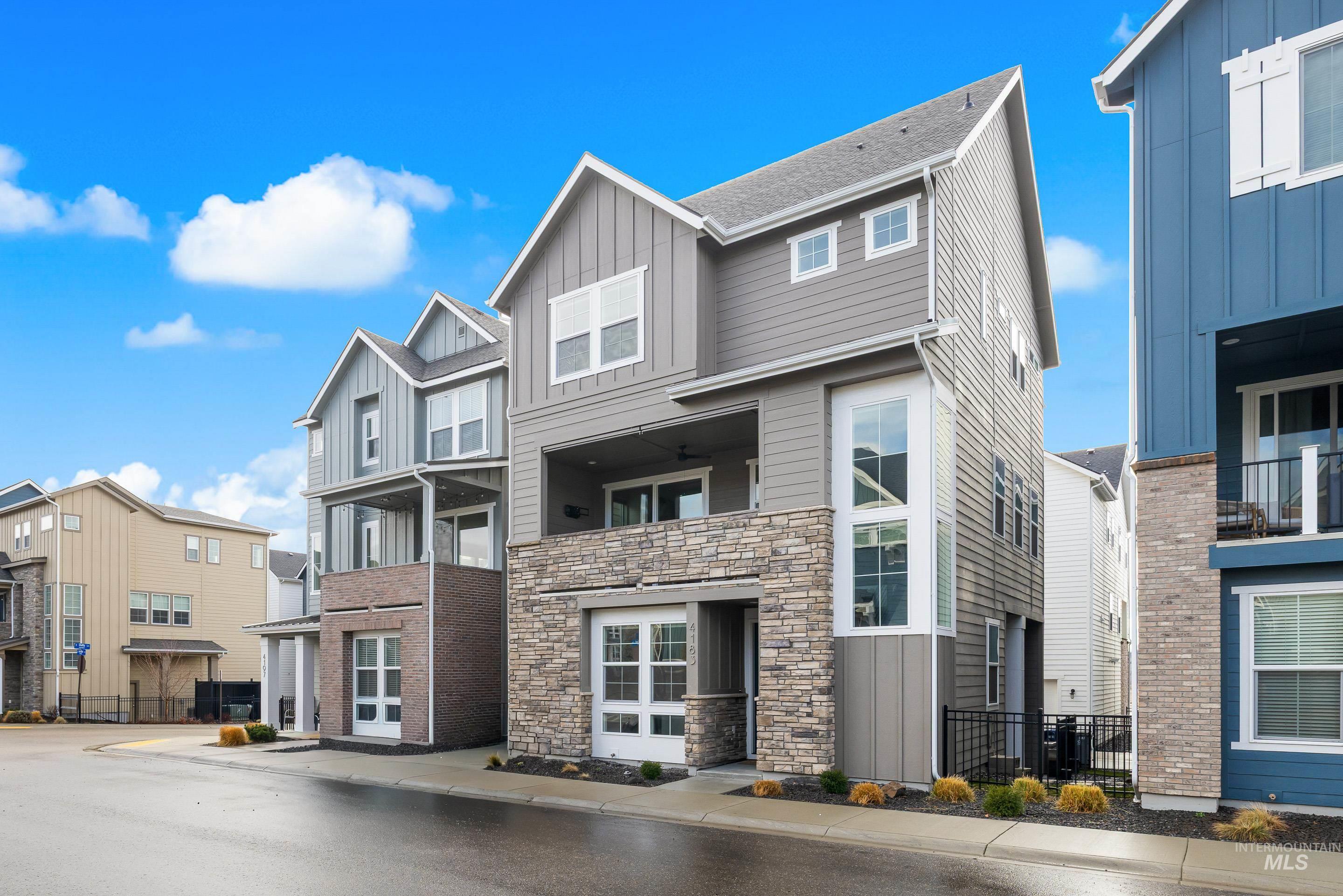 View of front of property with board and batten siding, a residential view, and stone siding