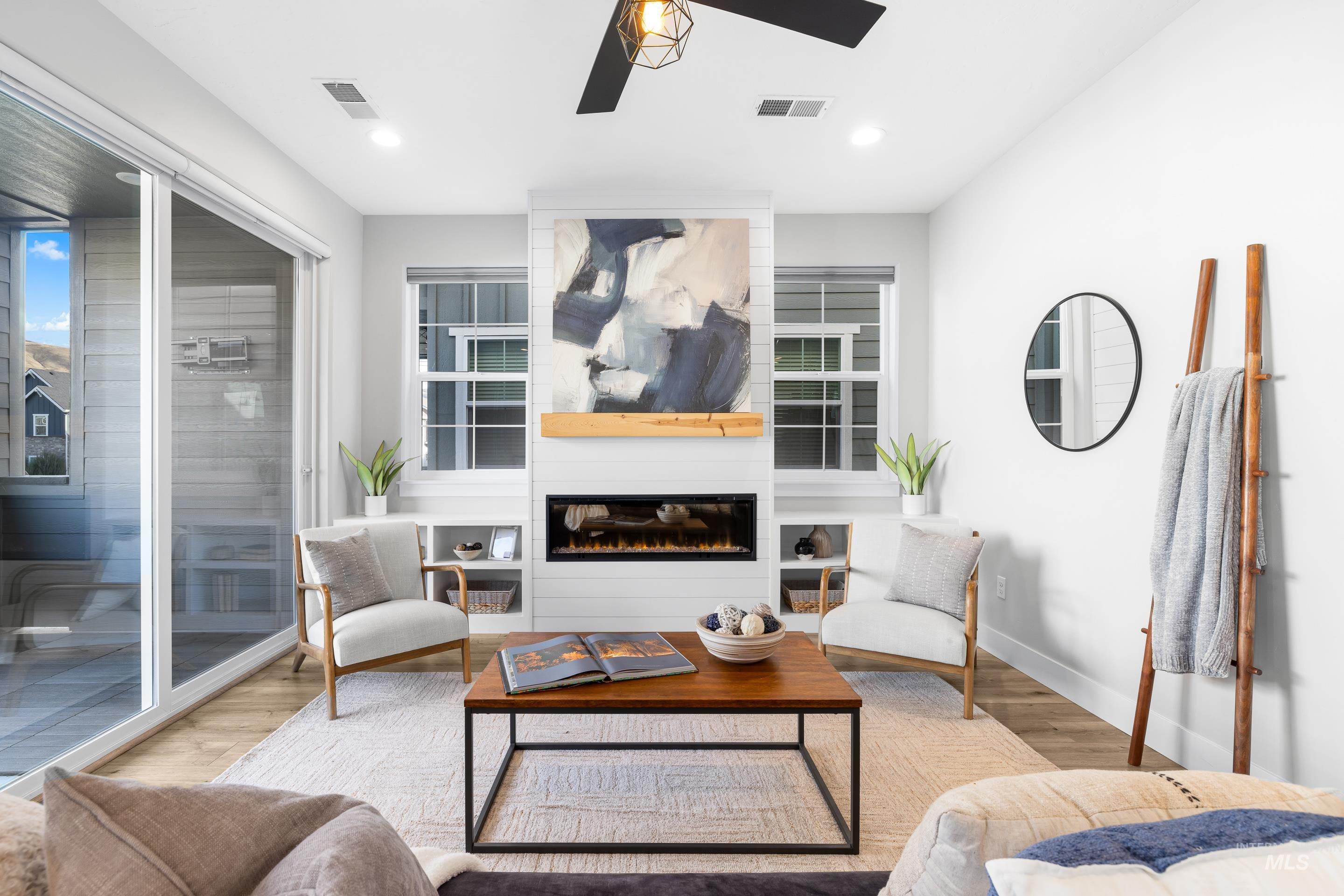 Living room featuring a large fireplace, wood finished floors, a ceiling fan, and recessed lighting