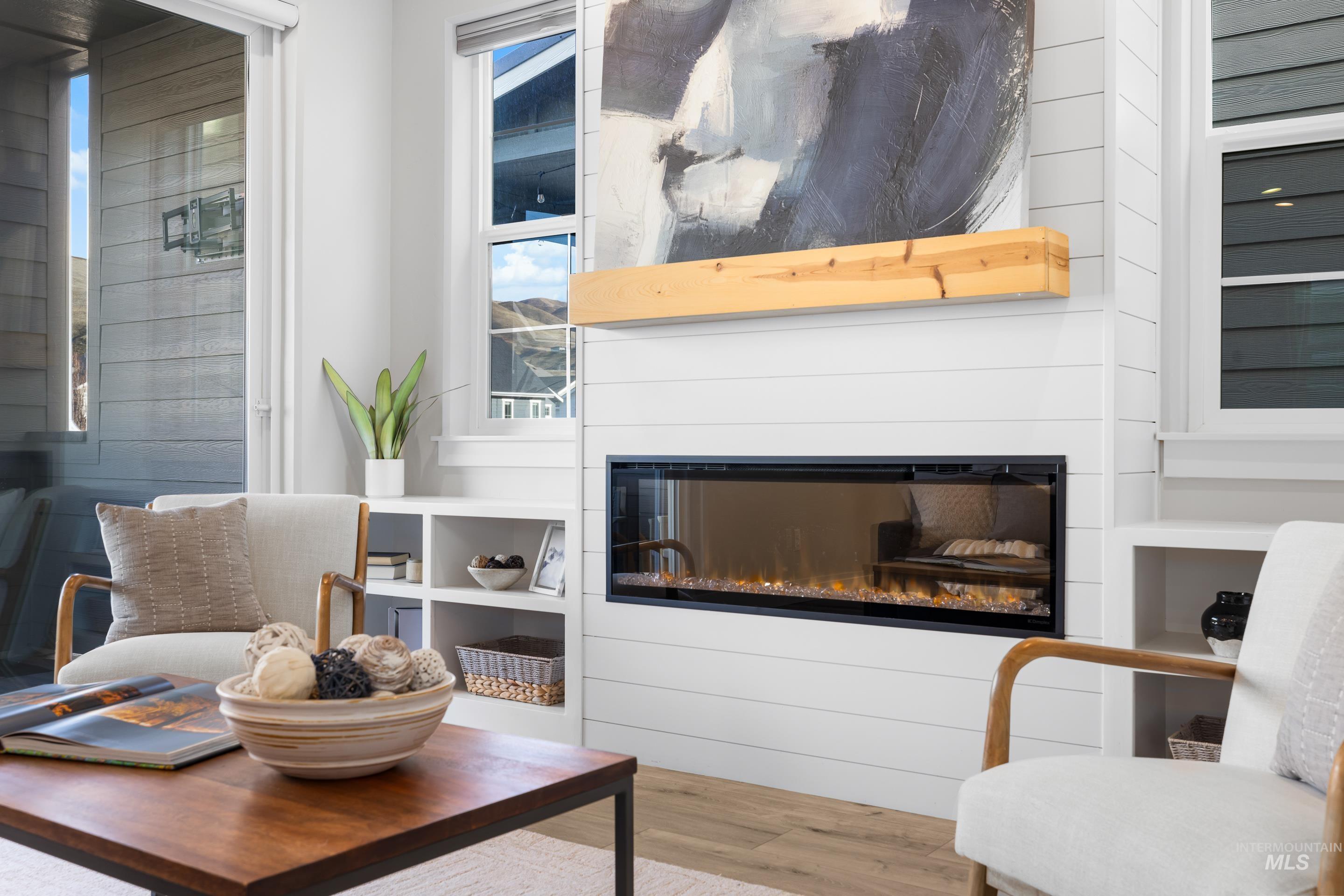 Sitting room with wood finished floors and a glass covered fireplace