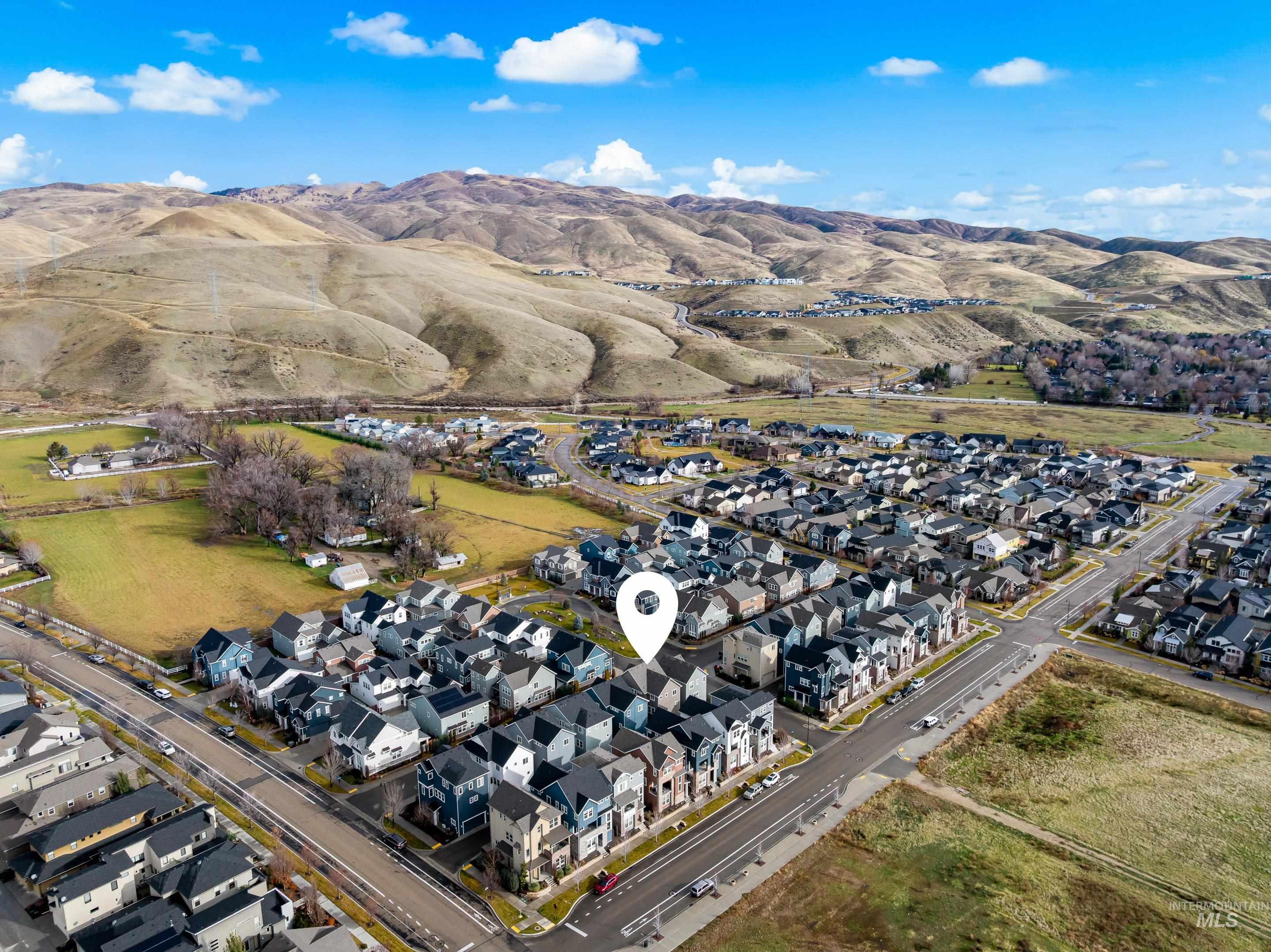 Aerial overview of property's location with nearby suburban area and mountains