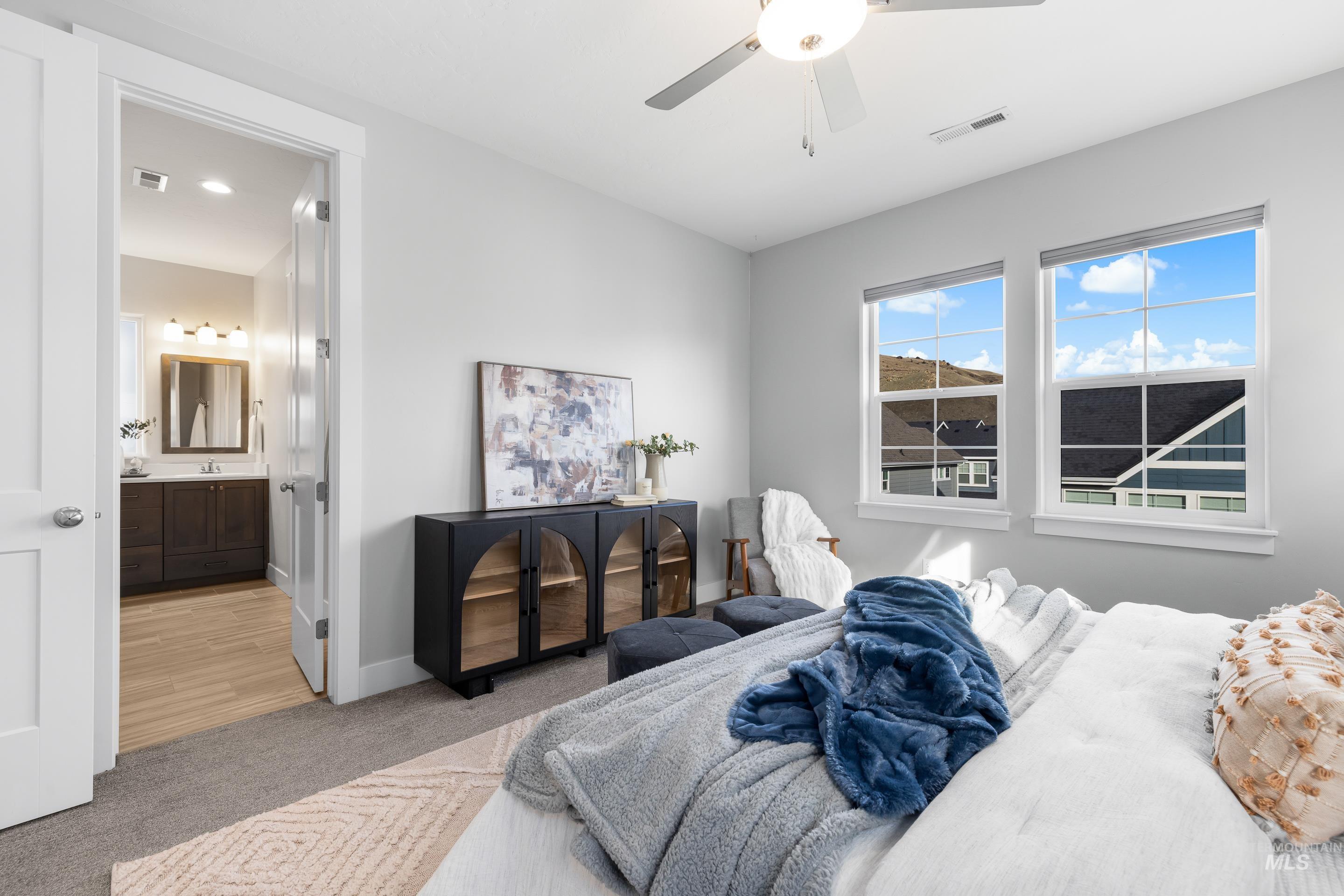 Carpeted bedroom featuring ceiling fan and baseboards