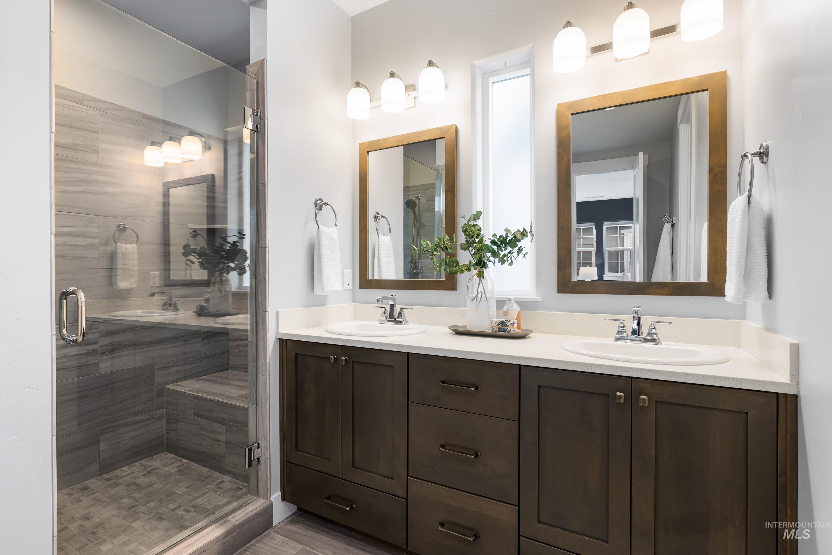 Bathroom with double vanity and a shower stall