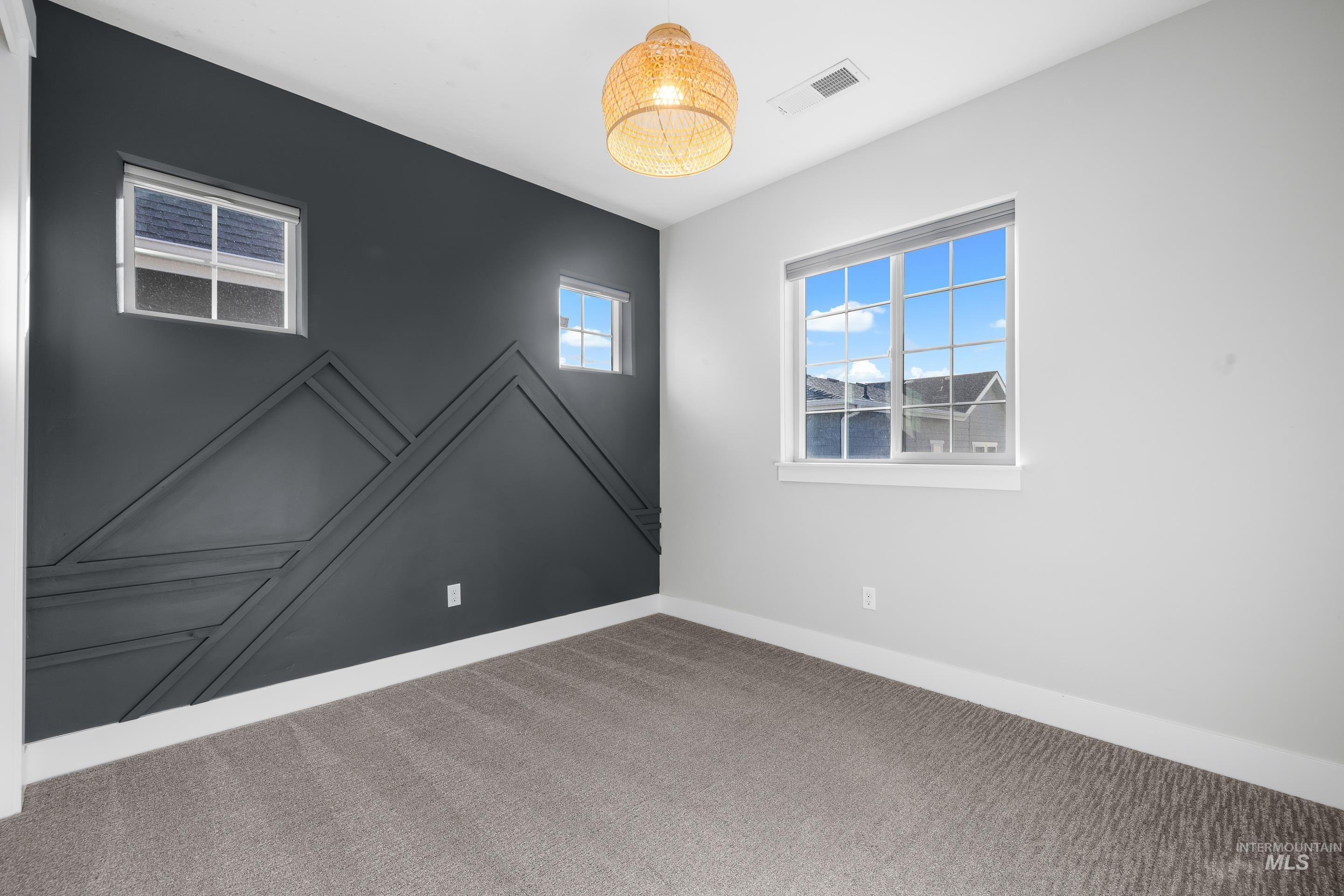 Carpeted spare room featuring baseboards