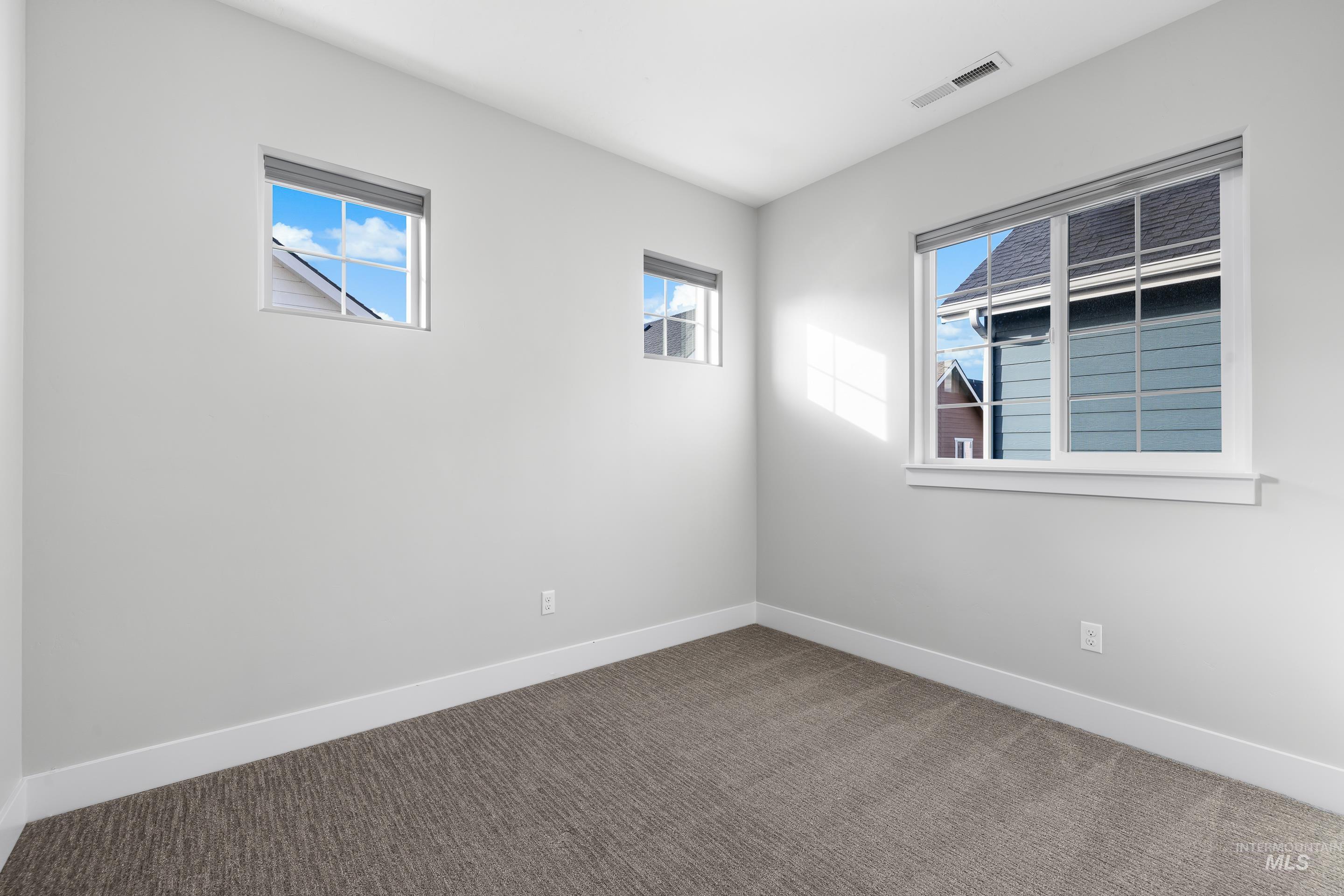 Carpeted spare room with baseboards