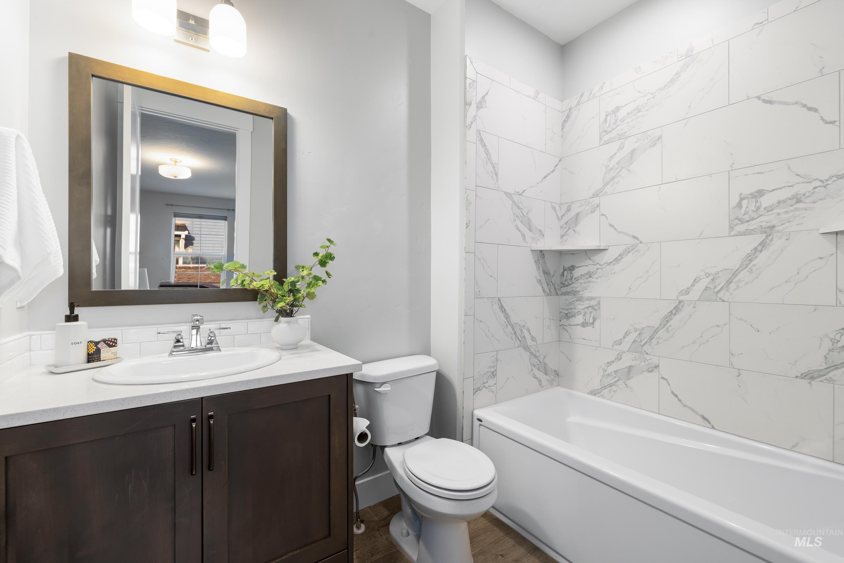 Full bathroom featuring vanity, shower / tub combination, and wood finished floors