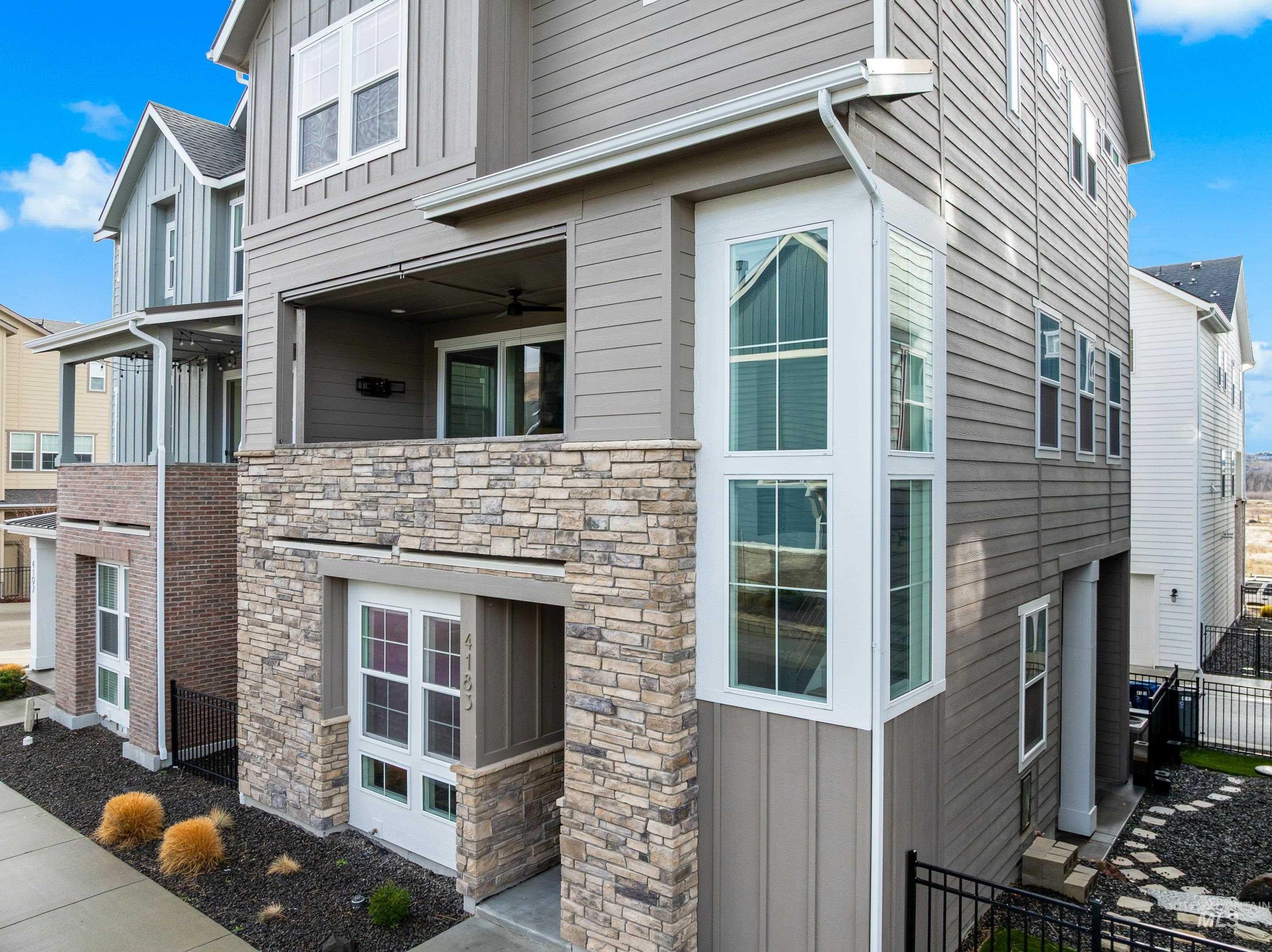 View of side of home featuring board and batten siding and stone siding