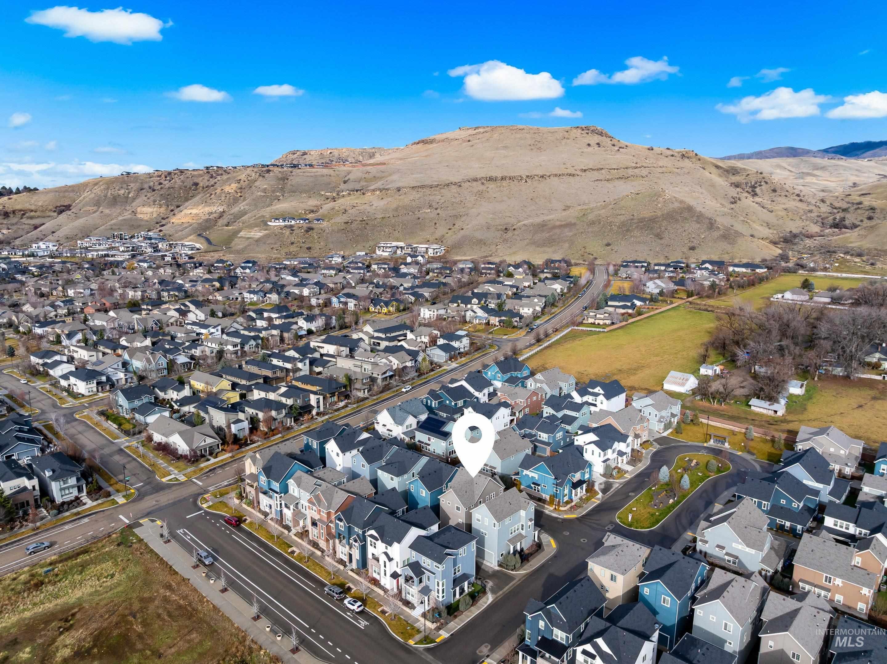 Aerial overview of property's location with nearby suburban area and a mountain backdrop