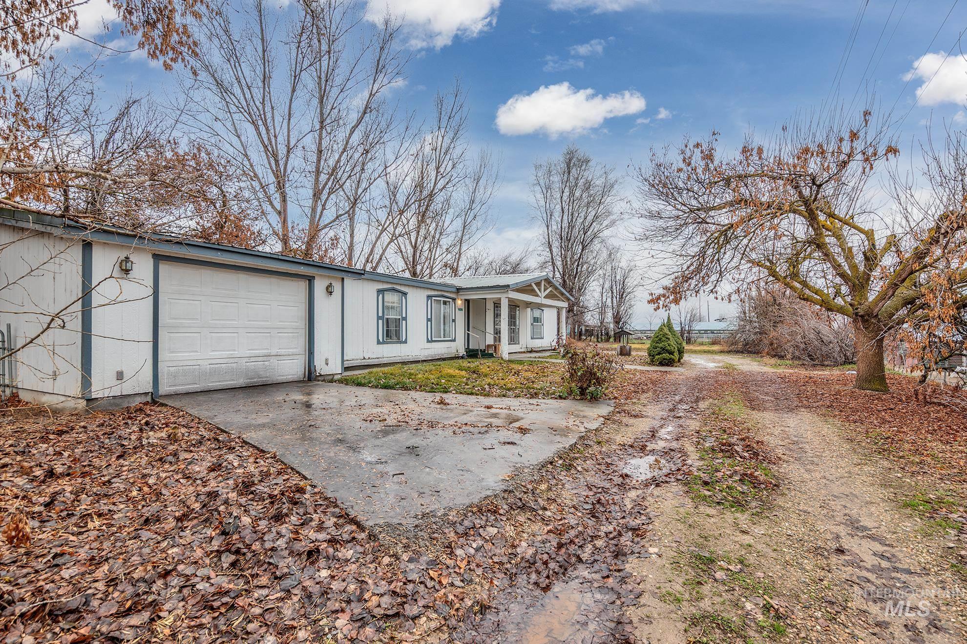 Ranch-style house featuring concrete driveway, an attached garage, and covered porch