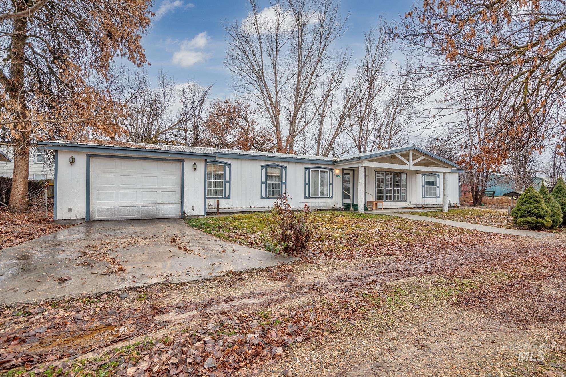 Ranch-style house featuring driveway, a garage, and covered porch