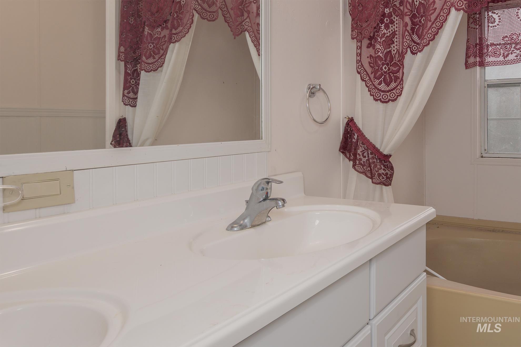 Full bathroom with double vanity and a bath