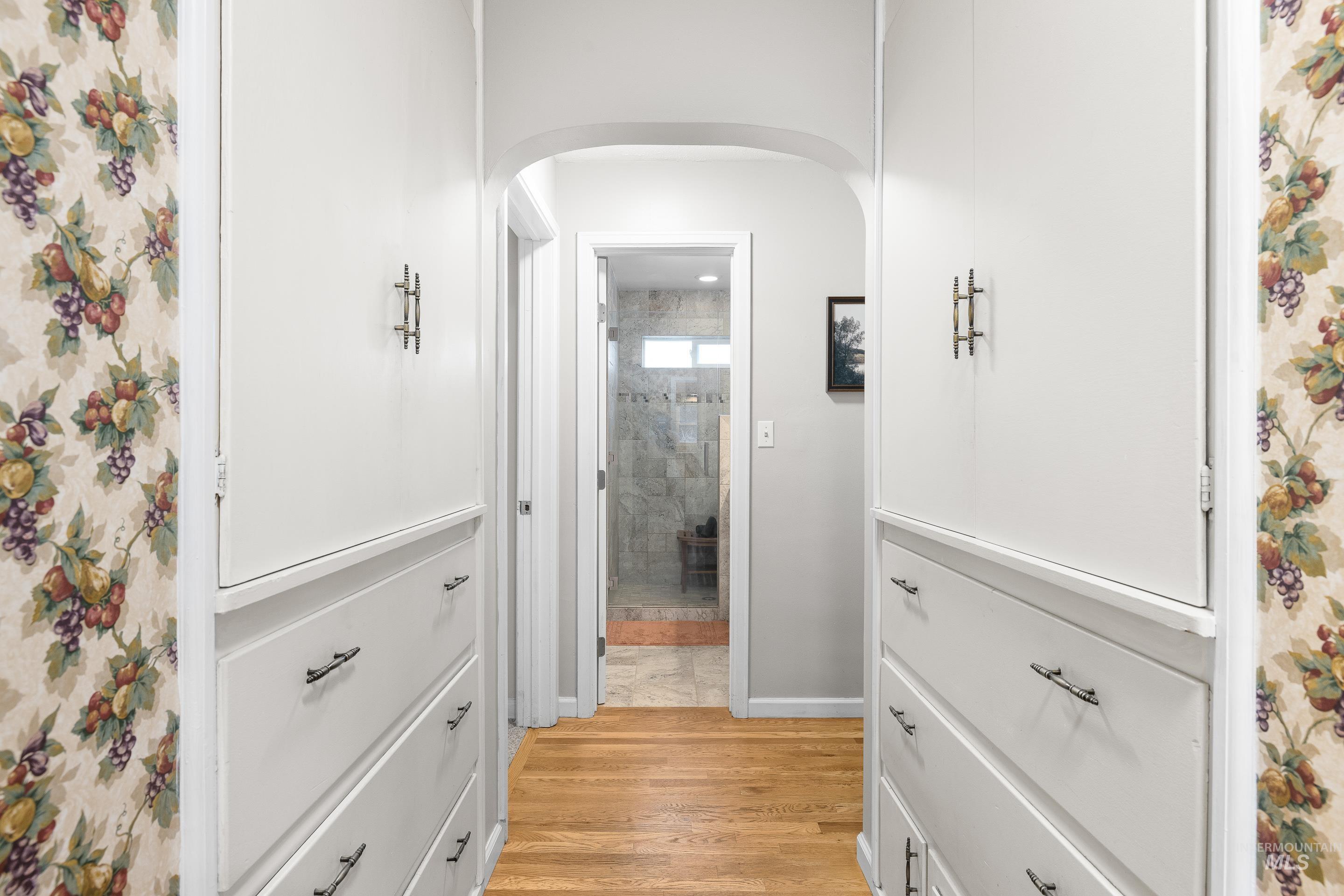 Hall featuring light wood-style flooring and arched walkways