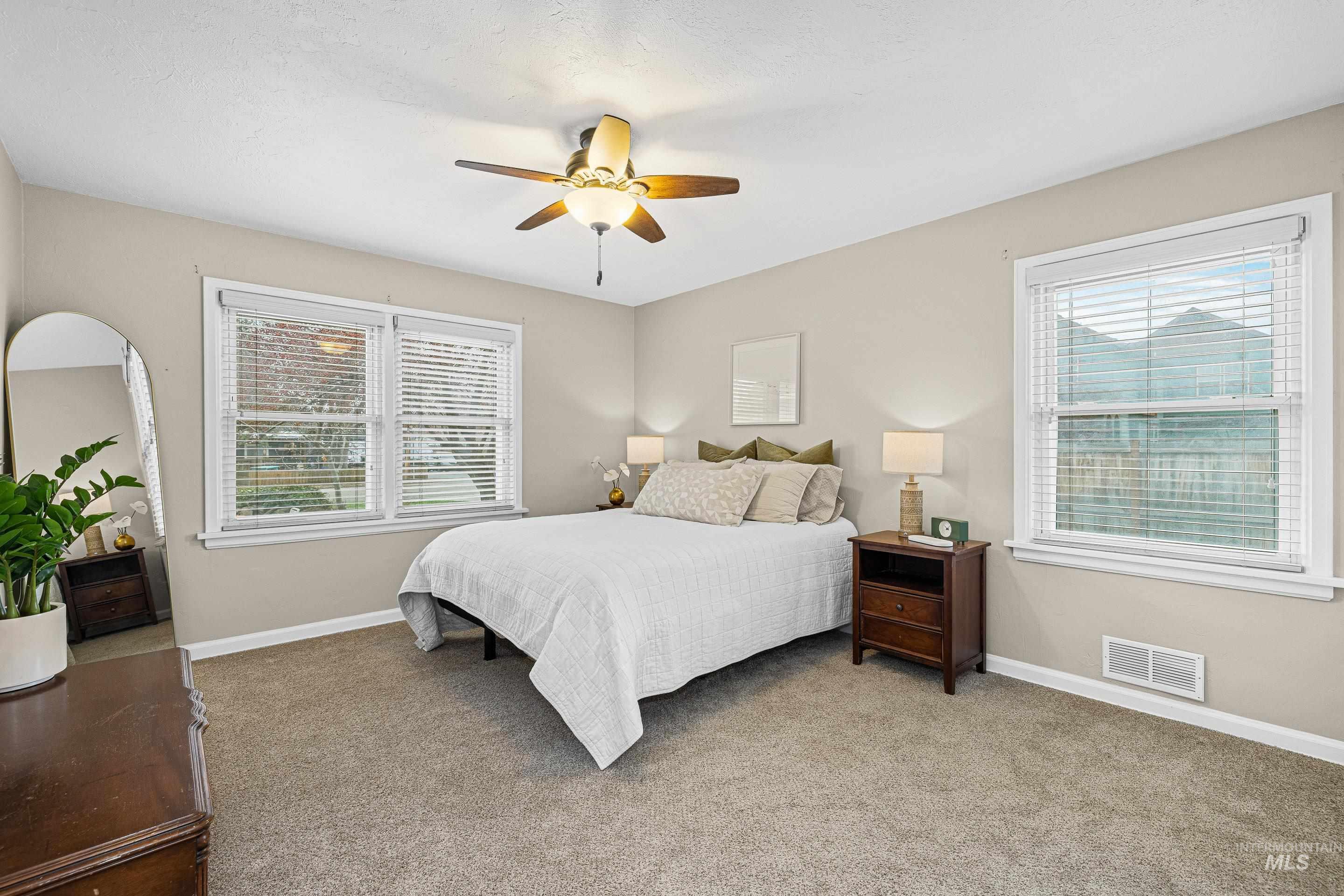 Carpeted bedroom featuring baseboards and ceiling fan